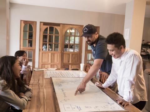 A group gathered around a table to plan together using a large whiteboard