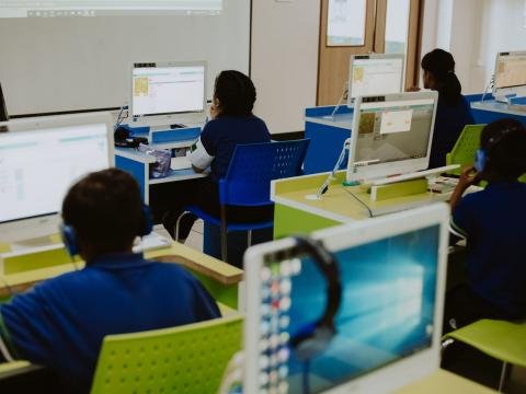Students use desktop computers during a classroom lesson.