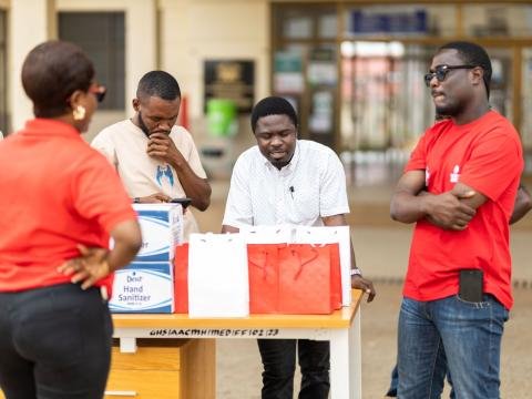 Volunteers organise supplies together at an outdoor community event.
